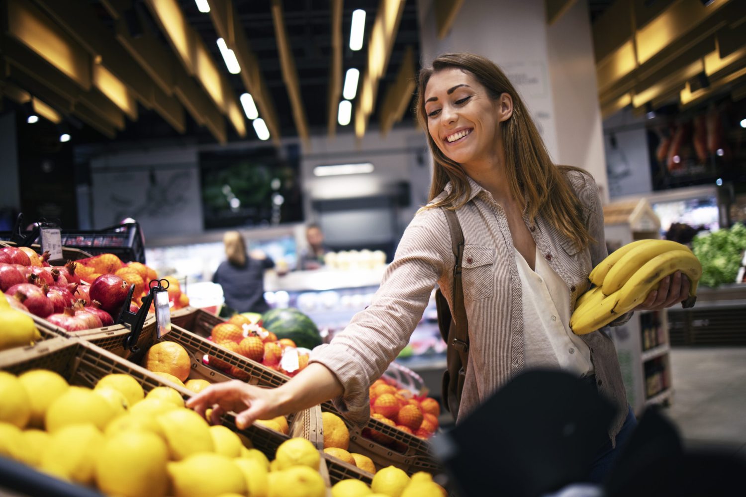Female buying food at supermarket grocery store.